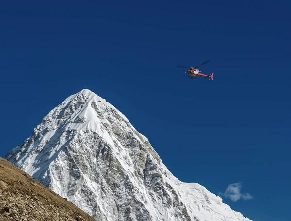 helicopter flying over mountain in everest region