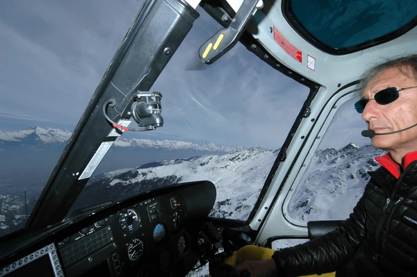 helicopter pilot flying in mountains