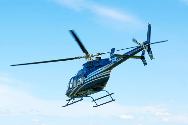 blue helicopter flying to everest